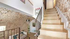 A staircase with beige steps and a stone wall on one side. - Helios Room 2, Conversano, Italy (Conversano)