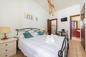 A neatly arranged bedroom with a bed, bedside tables, a desk, and a TV. - Helios Room 1, Conversano, Italy (Conversano)