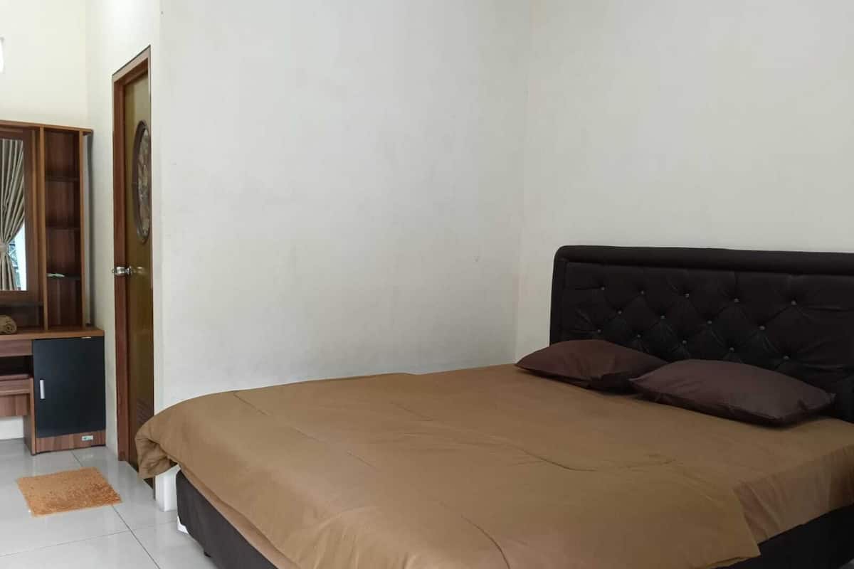 Een slaapkamer met een bed, een kledingkast en een bureau.