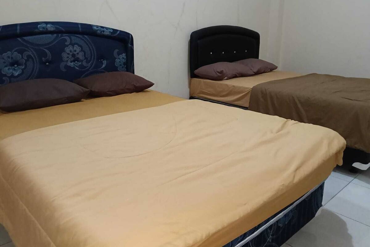 Een kamer met twee bedden, elk met hoofdeinde en kussens.