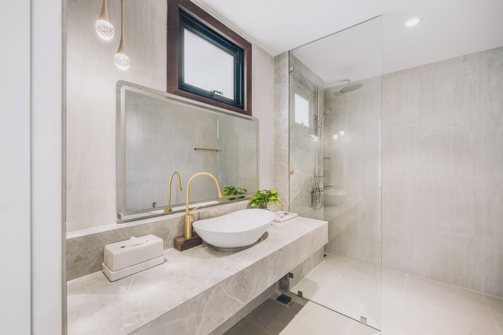 A modern bathroom with a large mirror, a vessel sink, and a walk-in shower.