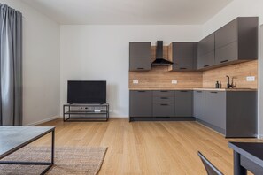 Eine moderne Küche mit grauen Schränken, einer Holz Arbeitsplatte und einer eingebauten Dunstabzugshaube.