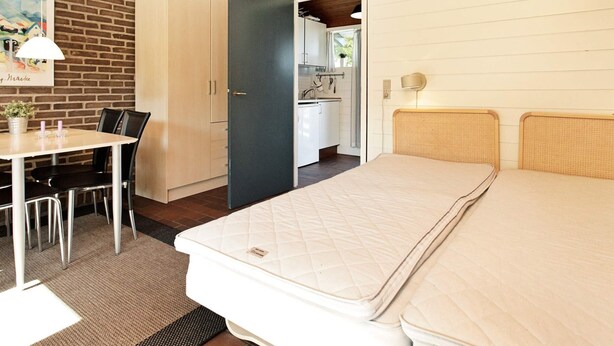 A room with a bed, a desk, and a kitchenette. - 5 Person Holiday Home in Aabenraa (Aabenraa)