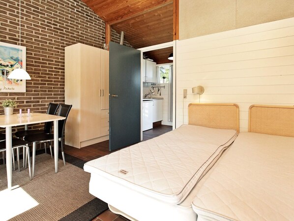 Ein Zimmer mit einem Bett, einem Schreibtisch und einer Küchenzeile.