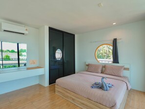A bedroom with a bed, a window, an air conditioning unit, and a view of greenery outside. - Pool&Play - Modern Private Pool Villa in Pattaya (Muang Pattaya)