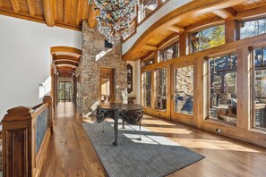 Ein geräumiger Flur mit Holzböden, Steinwänden und großen Fenstern.