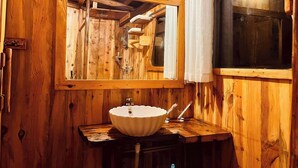 A wooden cabin bathroom with a large mirror, a white sink, and a window with curtains. - Senbo Eco Resort Cox's Bazar (Cox's Bazar)