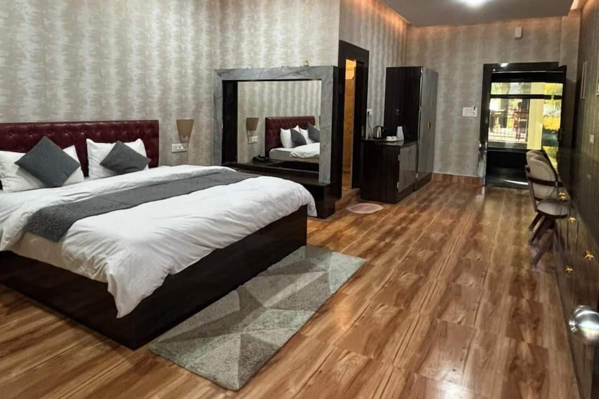 A spacious bedroom with a large bed, a ceiling fan, and a wooden floor.