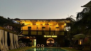 Ein Pool im Freien mit einer Holzterrasse und einem Schild mit der Aufschrift 'The Elite Resort' und 'Aqua Pool'.