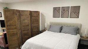 Una camera da letto con un letto, un armadio, comodini e decorazioni alle pareti.