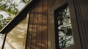 A wooden exterior wall with a window and a door frame. - Sunset Tiny House at Bluebush Estate X by Tiny Away (Rothbury)