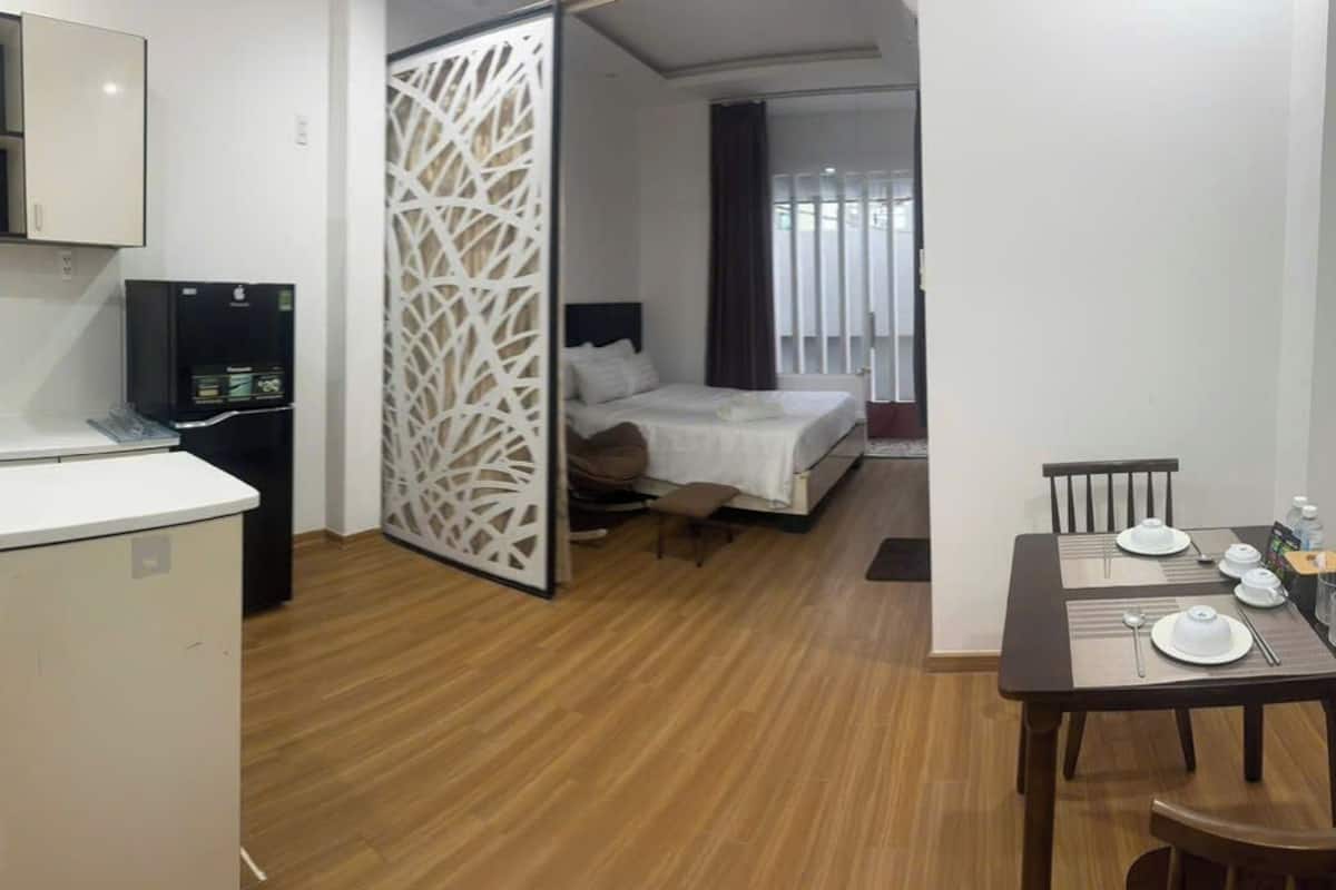 Une chambre d’hôtel compacte comprenant un coin cuisine, un lit et un espace repas.