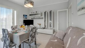 Un salon moderne comprenant un coin repas, un canapé et un téléviseur.