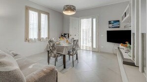 Un espace repas moderne avec une table ronde, des chaises et un luminaire suspendu.