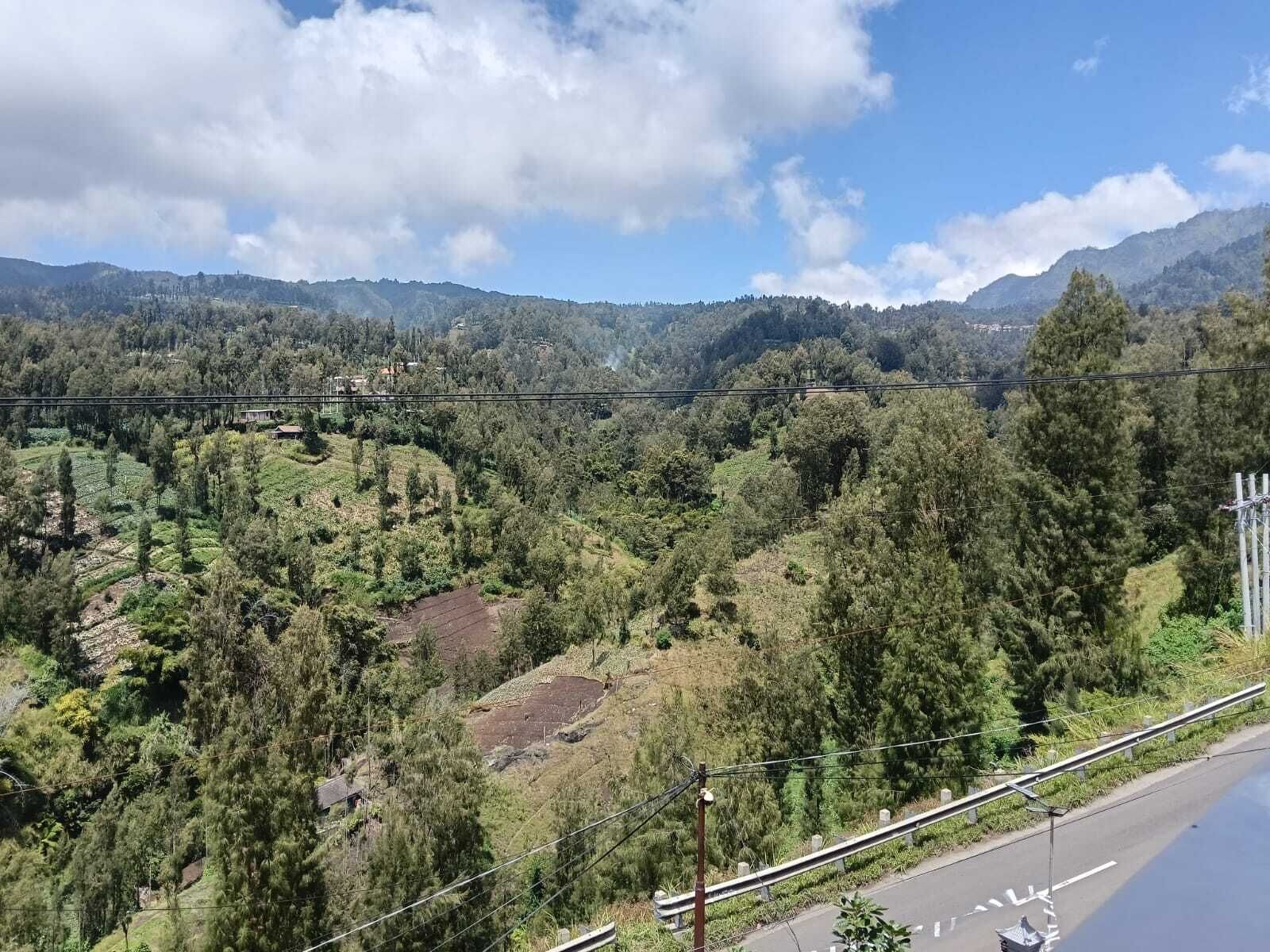 A mountainous landscape with a road and power lines.