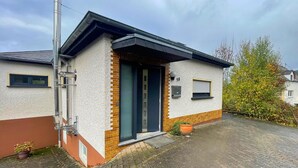 A modern single-story house with a brick facade, a dark-colored front door, and a small front yard. - Holiday Home in Birresborn With Balcony (Birresborn)