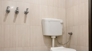 A modern bathroom with a white toilet, a shower, and a bidet. - Hotel Grill Inn (Lucknow)
