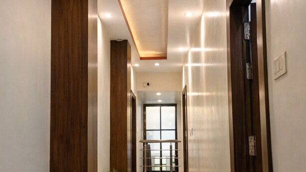 A modern hallway with a polished floor, wooden accents, and recessed lighting. - Hotel Grill Inn (Lucknow)