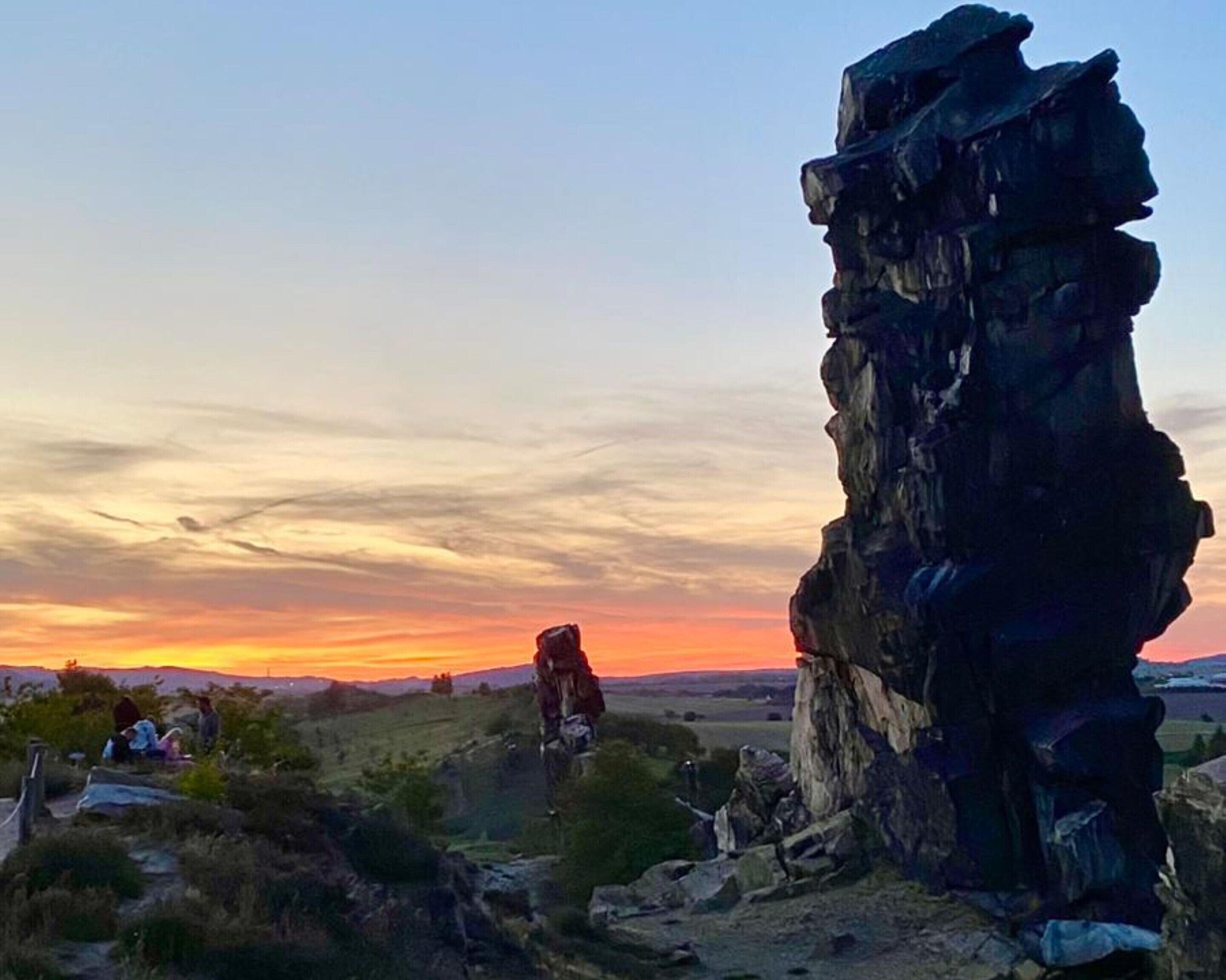 Une formation rocheuse accidentée, avec un coucher de soleil en arrière-plan.