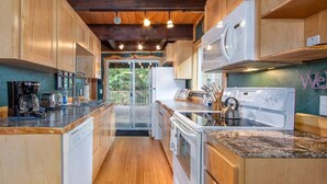 A kitchen with wooden cabinets, a built-in oven, a microwave, and a coffee maker. - Fir Tree Cabin | Grill, Fireplace (Packwood)