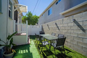 A patio with a table and chairs, a white gate, and a potted plant. - Historic Quiet Home W/Free Parking by Hollywood (Burbank)