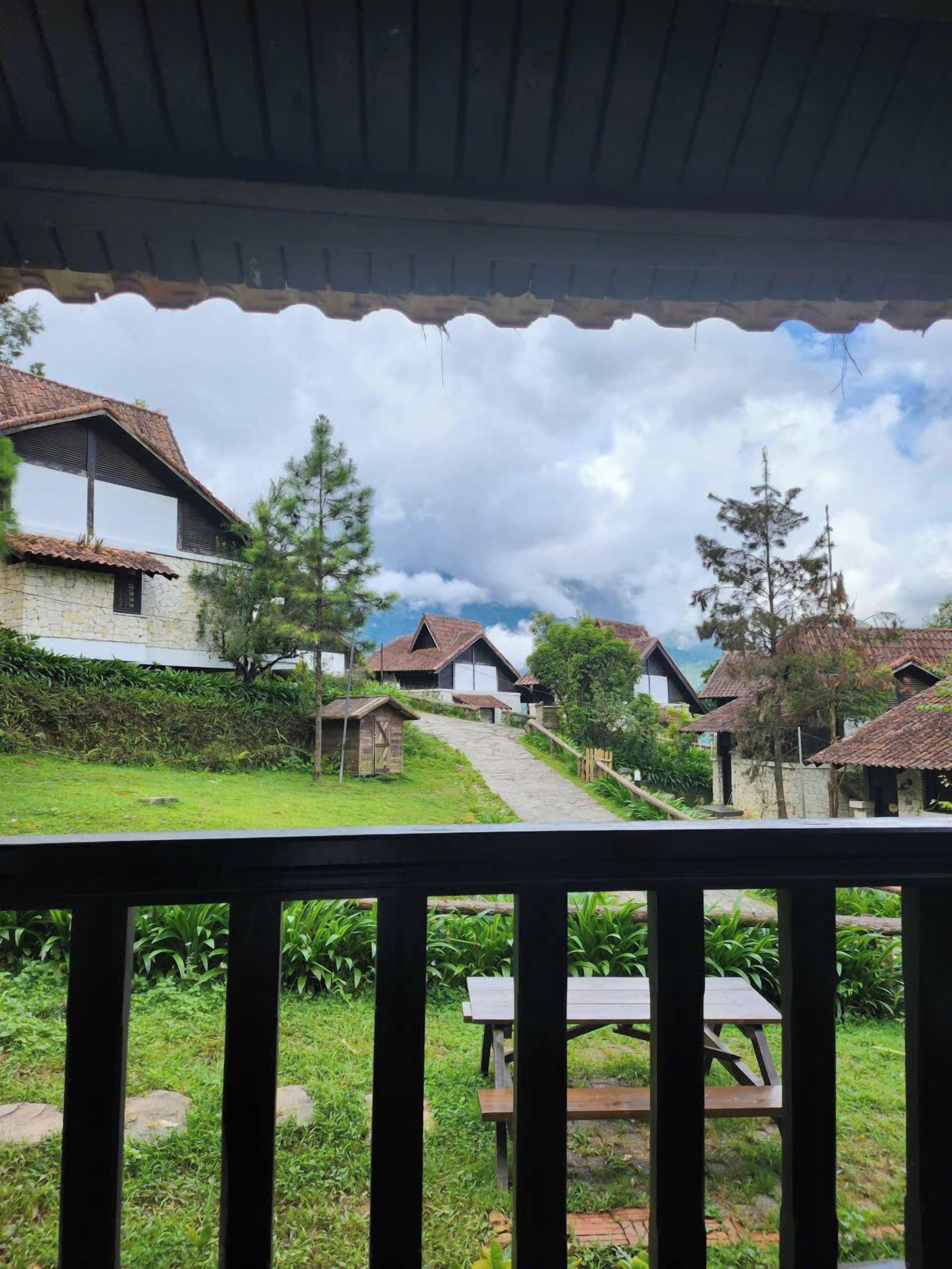 A rustic village with stone houses, a wooden pathway, and a picnic table.