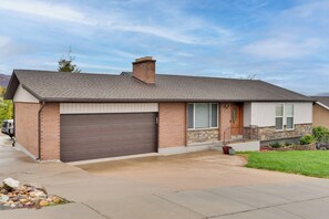 A single-story house with a brown garage door, a brick exterior, and a stone foundation. - Mountain-View Retreat w/ Hot Tub in Centerville! (Centerville)