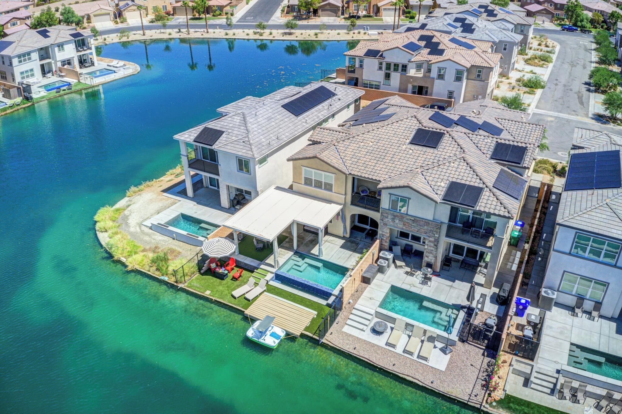 A residential area with houses, a swimming pool, and a dock.
