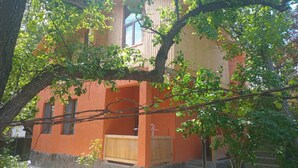Un bâtiment à l’extérieur en bois, avec une fenêtre visible et une petite structure en bois à l’entrée.