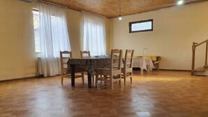 Un espace repas avec une table et des chaises en bois, un plancher en bois et un escalier.