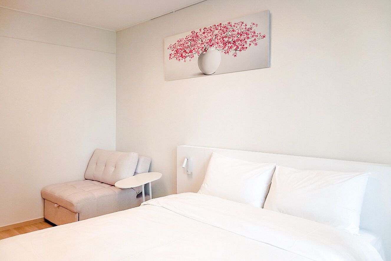 Ein modernes Schlafzimmer mit einem Bett, einem kleinen Tisch und einem Stuhl.