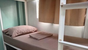 Een stapelbed met een eenpersoonsbed bovenop en een onderbed.