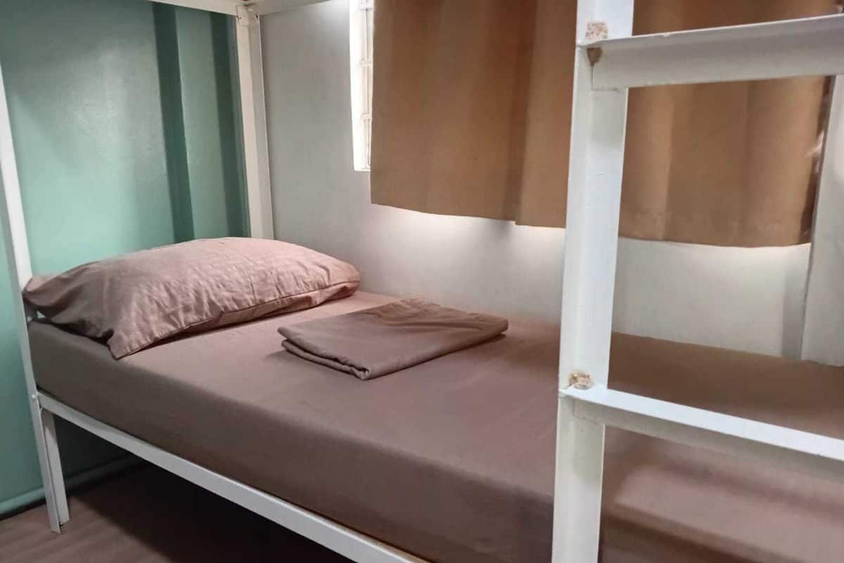 Ein Etagenbett mit einem Einzelbett oben und einem Schlafplatz unten.