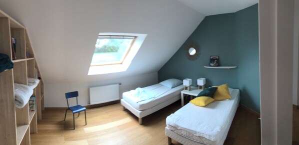 A dormitory room with a skylight, a single bed, a chair, a small table with speakers, and a shelf with items. - Recent house, spacious, 4 min walk from Trémazan beach, sleeps 8 (Landunvez)