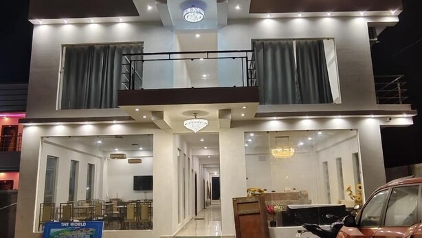 A two-story hotel named "Hotel Royal Beach Exotic." It features a modern design with a prominent sign at the top, large windows, and a spacious lobby area. - Hotel Royal Beach Exotica (Kanthi)