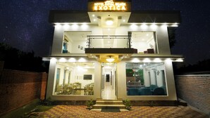 A modern hotel with a sign reading "Hotel Royal Beach Exotica." It features a spacious lobby with a staircase leading to the upper floor. - Hotel Royal Beach Exotica (Kanthi)