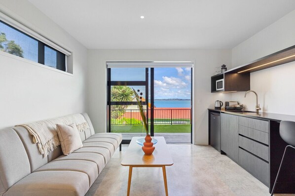 TV - Elegant Coastal Studio with Beach Access & Ocean Views (Auckland)