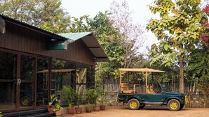 A building with large windows and a vehicle parked outside. - The Farm Stay by Aamaghati (Sawai Madhopur)