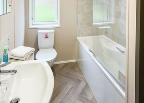 A bathroom with a white sink, toilet, and bathtub.