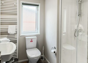 A bathroom with a toilet, bidet, and shower.