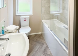 A bathroom with a white sink, toilet, and bathtub.