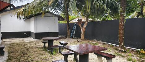 A patio area with outdoor seating and a palm tree.