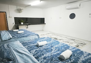 A hotel room with two beds, a small kitchenette, and a round mirror on the wall. - OYO 91244 Aufa Chalet (Kuala Terengganu)