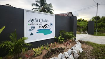 Señalización para Aufa Chalet, con información de contacto y un gráfico de una casa sobre una isla.