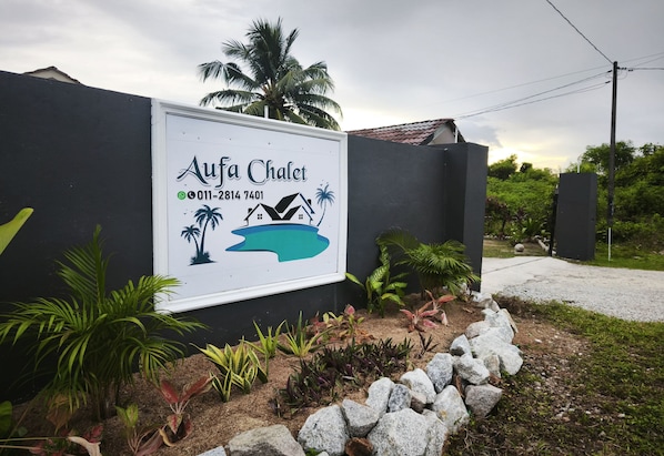 A signboard for Aufa Chalet with contact information and a graphic of a house on an island. - OYO 91244 Aufa Chalet (Kuala Terengganu)
