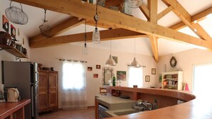 A kitchen with wooden beams, a refrigerator, a sink, and a dining area. - Holiday Home with Private Pool, Vagnas (Vagnas)