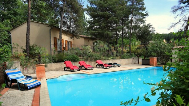 A swimming pool with lounge chairs, a building with a balcony, and surrounding greenery. - Holiday Home with Private Pool, Vagnas (Vagnas)