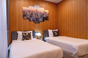 A hotel room with two beds, a cityscape artwork on the wall, and a nightstand with a lamp. - The View Villa (Chiang Dao)