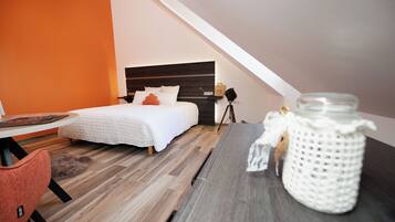 Een slaapkamer met een bed, een nachtkastje, een lamp en een tafel met een pot.