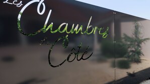 Une enseigne portant l’inscription « Les Chambres de Cote » sur une surface réfléchissante.